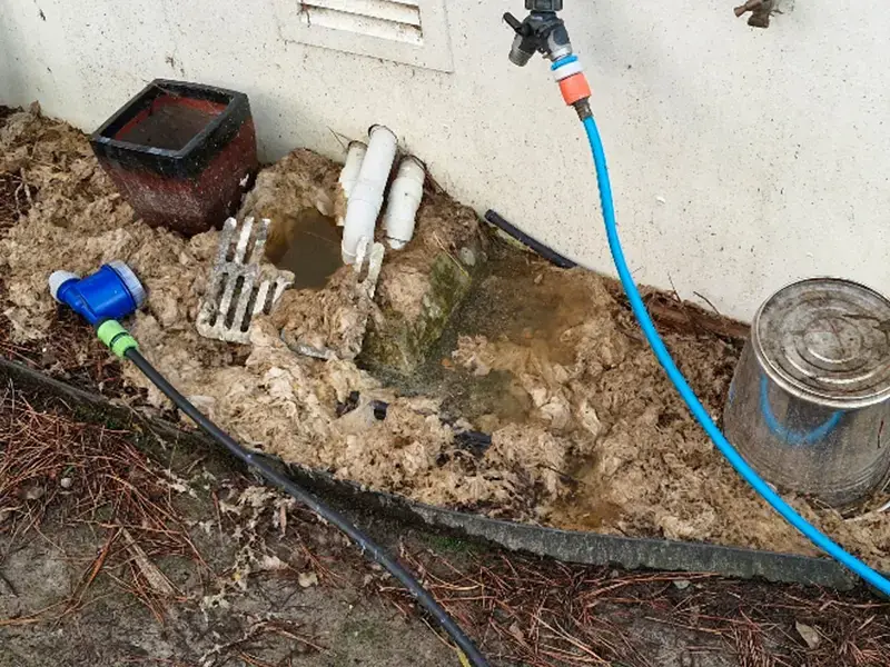 Blocked gully trap being unblocked with hydro jetting equipment