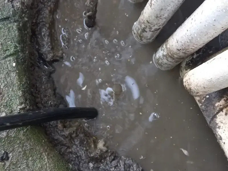 High-pressure hydro jetting hose clearing a blocked drain